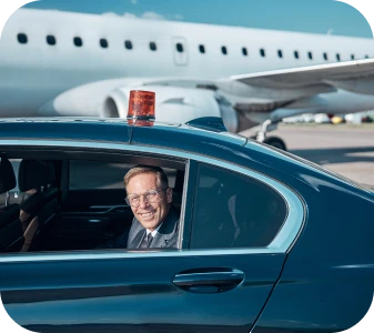 Chauffeur at the airport with aircraft in the background