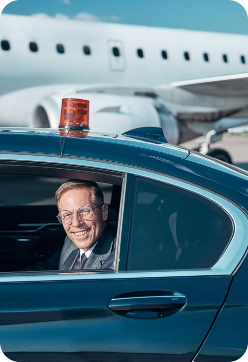 Chauffeur at the airport with aircraft in the background